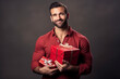 happy handsome man holds red and pink gift box, valentine's day on gray