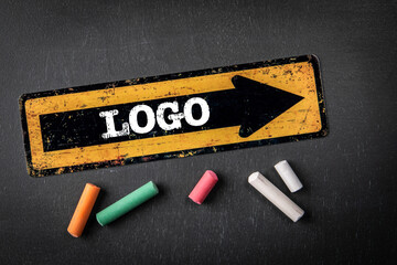 Wall Mural - logo. direction arrow with text on a dark chalkboard background