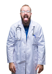 Sticker - Young caucasian doctor man wearing medical white coat over isolated background sticking tongue out happy with funny expression. Emotion concept.