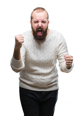 Sticker - Young caucasian hipster man wearing winter sweater over isolated background angry and mad raising fist frustrated and furious while shouting with anger. Rage and aggressive concept.