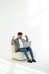 Wall Mural - Businessman smiling and enjoying on a beach chair with a laptop computer on white background