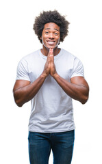 Sticker - Afro american man over isolated background praying with hands together asking for forgiveness smiling confident.