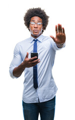 Wall Mural - Afro american business man texting using smartphone over isolated background with open hand doing stop sign with serious and confident expression, defense gesture