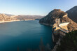 © ADDICTIVE STOCK - A dam nestled between mountainous terrain with a reservoir displaying low water levels indicative of drought conditions
