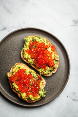 Canvas Print - Red caviar and guacamole toast with rye bread.