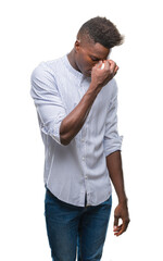 Wall Mural - Young african american man over isolated background tired rubbing nose and eyes feeling fatigue and headache. Stress and frustration concept.