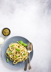 Wall Mural - Homemade pasta, spaghetti, linguine with green pesto and basil. Italian healthy food concept with copy space, top view.