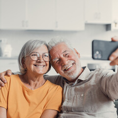 Sticker - Happy old couple taking selfie on cellphone, smiling senior mature spouses middle aged wife and retired husband laughing holding phone make self portrait on smartphone camera, focus on mobile display.