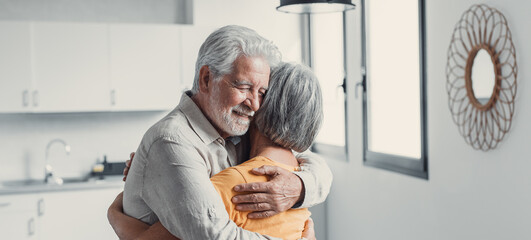 Wall Mural - Happy mature couple in love embracing, laughing grey haired husband and wife with closed eyes, horizontal banner, middle aged smiling family enjoying tender moment, happy marriage, sincere feelings.