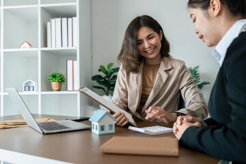 Wall Mural - Businesswoman using a calculator to calculate numbers on a company's financial documents, she is analyzing historical financial data to plan how to grow the company. Financial concept