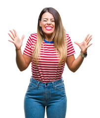 Wall Mural - Young beautiful woman casual look over isolated background celebrating mad and crazy for success with arms raised and closed eyes screaming excited. Winner concept