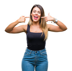 Wall Mural - Young beautiful woman over isolated background smiling confident showing and pointing with fingers teeth and mouth. Health concept.