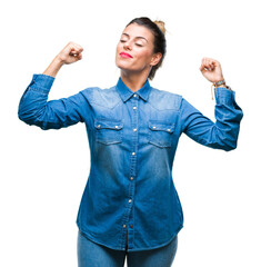 Sticker - Young beautiful woman over isolated background showing arms muscles smiling proud. Fitness concept.