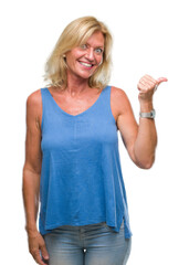 Sticker - Middle age blonde woman over isolated background smiling with happy face looking and pointing to the side with thumb up.