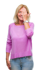 Sticker - Middle age blonde woman over isolated background covering one eye with hand with confident smile on face and surprise emotion.