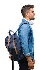 Wall Mural - Young handsome tourist man wearing headphones and backpack over isolated background looking to side, relax profile pose with natural face with confident smile.