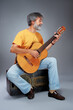 © luengo_ua - Aged bearded man with an acoustic guitar