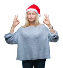 Poster - Young caucasian woman wearing christmas hat over isolated background relax and smiling with eyes closed doing meditation gesture with fingers. Yoga concept.