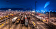 Panoramic view of large shunting yard and freight station in Hagen Germany on a cold winters night. Brightly illuminated colorful infrastructure with trains, cars and wagons an many parallel tracks.