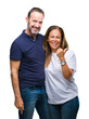 © Krakenimages.com - Middle age hispanic casual couple over isolated background smiling with happy face looking and pointing to the side with thumb up.