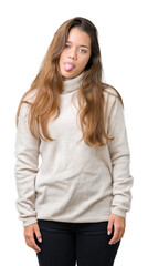 Sticker - Young beautiful brunette woman wearing turtleneck sweater over isolated background sticking tongue out happy with funny expression. Emotion concept.