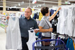 © caftor - Mature couple choosing tank tops in clothes department in grocery store