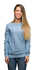 Poster - Beautiful young woman wearing sweater and jeans with a happy face standing and smiling with a confident smile showing teeth