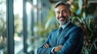 © KKC Studio - CEO of a happy company, standing with arms crossed in his office. Grinning, close-up.