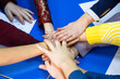 © Vadim - Group of People Putting Their Hands Together in Unity and Support. A diverse group of individuals coming together by joining hands in unity and solidarity.