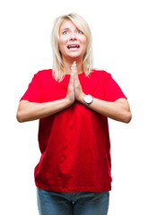 Wall Mural - Young beautiful blonde woman wearing red t-shirt over isolated background begging and praying with hands together with hope expression on face very emotional and worried. Asking for forgiveness.