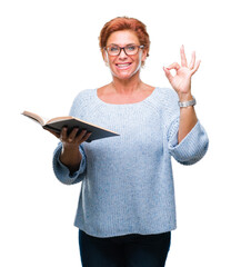 Canvas Print - Senior caucasian woman reading a book over isolated background doing ok sign with fingers, excellent symbol