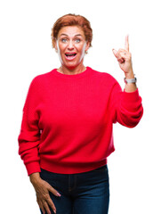 Poster - Atrractive senior caucasian redhead woman wearing winter sweater over isolated background pointing finger up with successful idea. Exited and happy. Number one.