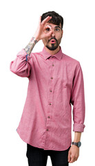 Sticker - Young handsome man wearing pink shirt over isolated background doing ok gesture shocked with surprised face, eye looking through fingers. Unbelieving expression.