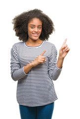 Sticker - Young afro american woman over isolated background smiling and looking at the camera pointing with two hands and fingers to the side.