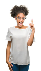 Wall Mural - Young afro american woman wearing glasses over isolated background pointing finger up with successful idea. Exited and happy. Number one.