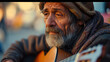 close-up portrait of an old poor street musician playing the guitar with a sad look