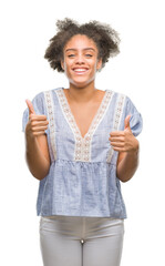 Sticker - Young afro american woman over isolated background success sign doing positive gesture with hand, thumbs up smiling and happy. Looking at the camera with cheerful expression, winner gesture.