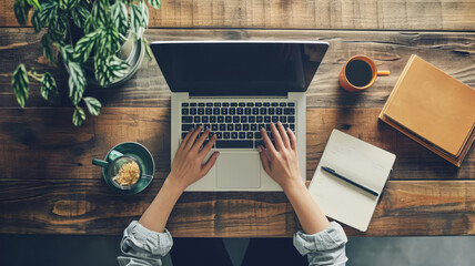 top view of person working on laptop computer with hands