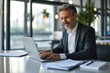 © Lumina Frame - Happy mid aged professional business man company executive ceo manager lawyer sitting at desk in office using laptop working on plan overview checking, Generative AI