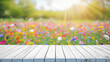 Frühlingsanfang. Weißer leerer Holztisch mit unscharfer bunter Blumenwiese im Hintergrund. Platz für Warenpräsentation, Produkt oder Text