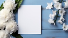 A White Card Surrounded By White Flowers On A Blue Table