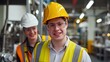© sirisakboakaew - A young man with Down syndrome wears a yellow hard hat and a life jacket. There is work in an industrial factory.