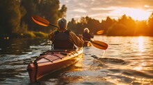 Senior Couple Kayaking On The Lake Together At Sunset