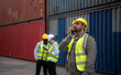 © Wosunan - Group of engineers working with laptop in the container yard. This is a freight transportation and distribution warehouse.