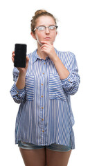 Poster - Young blonde woman using smartphone serious face thinking about question, very confused idea