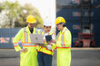 © Wosunan - Group of engineers working with laptop in the container yard. This is a freight transportation and distribution warehouse.