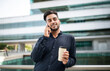 © Prostock-studio - Cheerful middle eastern employee guy talking on smartphone outdoors