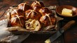 Tray of Hot Cross Buns with Butter.
A wooden tray filled with glazed hot cross buns beside a bowl of butter.