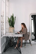 © Елизавета Старкова - A business woman in a jacket is looking at a laptop and talking on a mobile phone using technology while sitting at her desk in the office. Multitasking. Selective focus