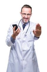 Poster - Middle age senior hoary doctor man texting using smartphone over isolated background with open hand doing stop sign with serious and confident expression, defense gesture